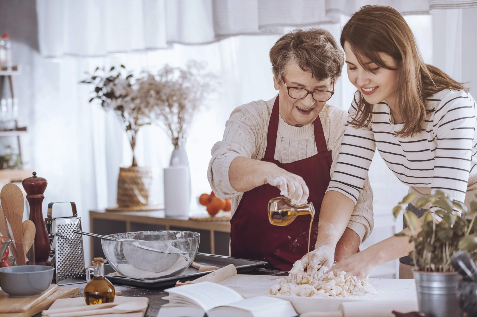 An older woman and a younger woman spending time together in a kitchen